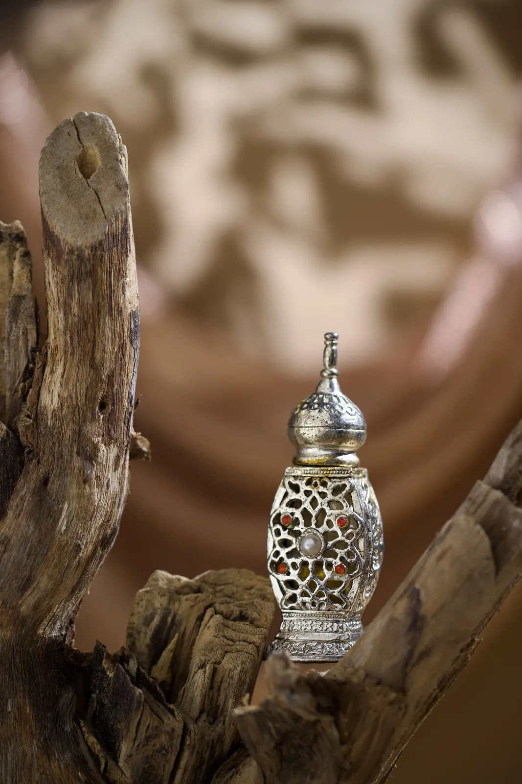 An attar bottle on wood, table-top photography