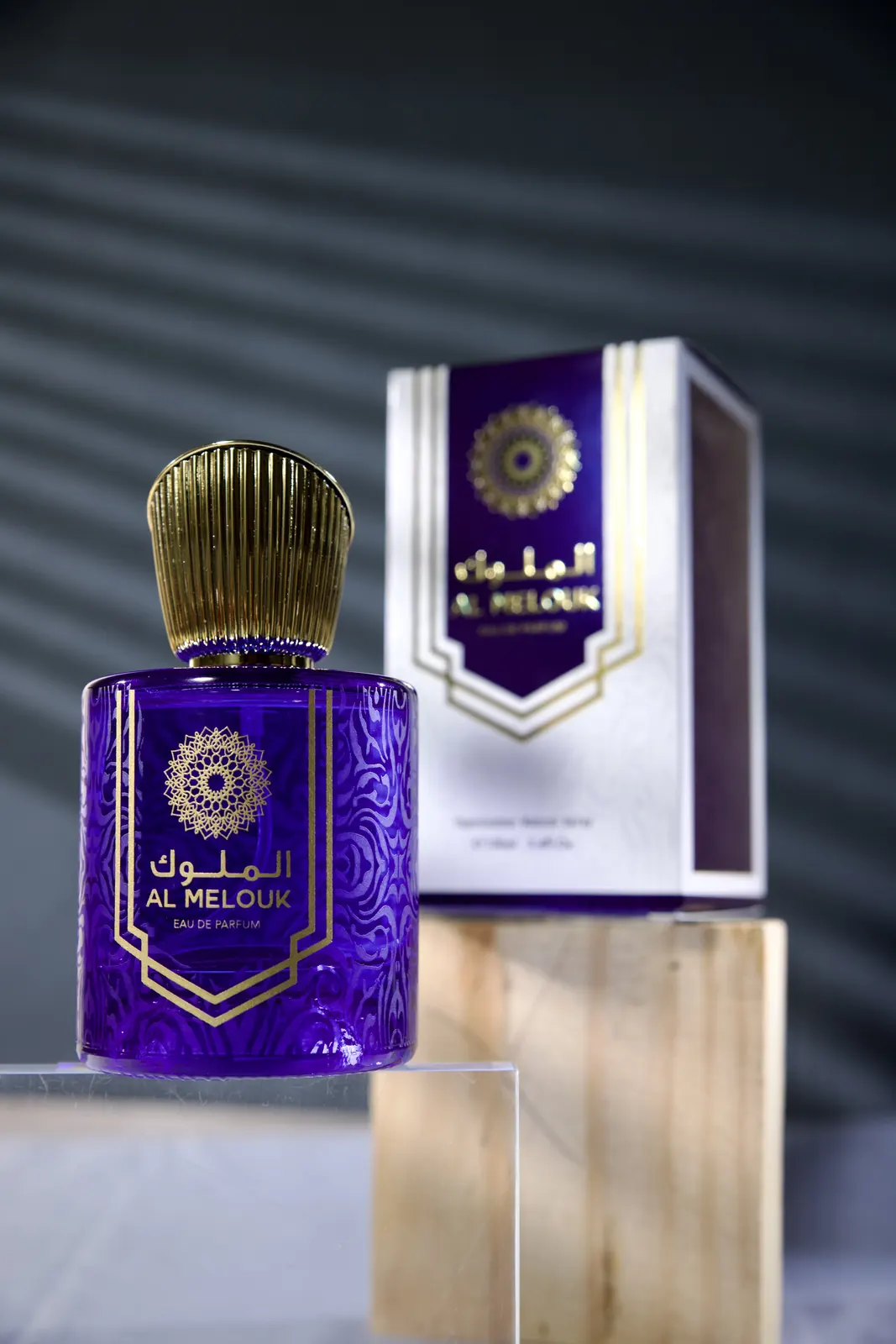 An Al Melouk perfume bottle on a lit table-top set